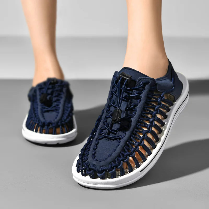 Navy blue sandals with white soles on a gray background