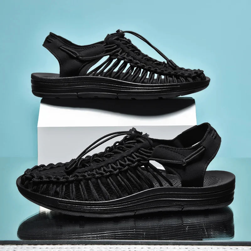 Black sandals with woven design on a light blue background