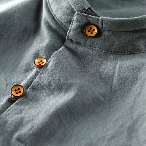 Close-up of a gray shirt with buttons on a plain background