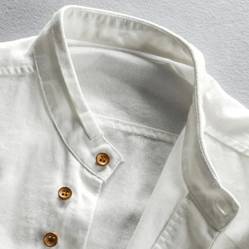Close-up of a light gray denim shirt with brown buttons on a gray background