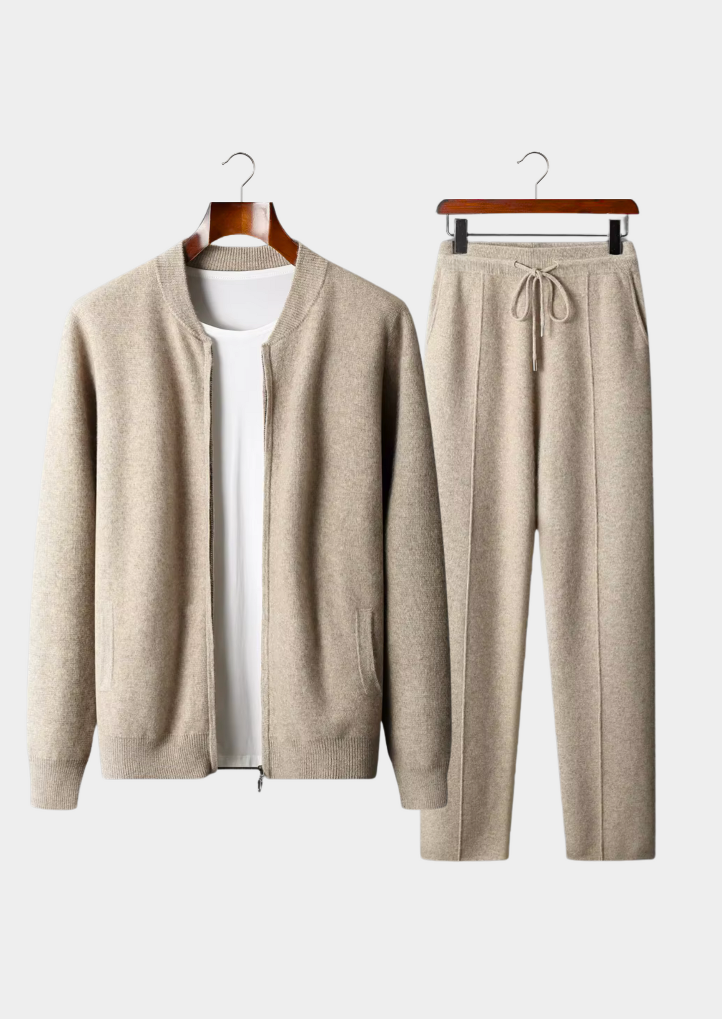 Beige cardigan and pants set on hangers against a white background
