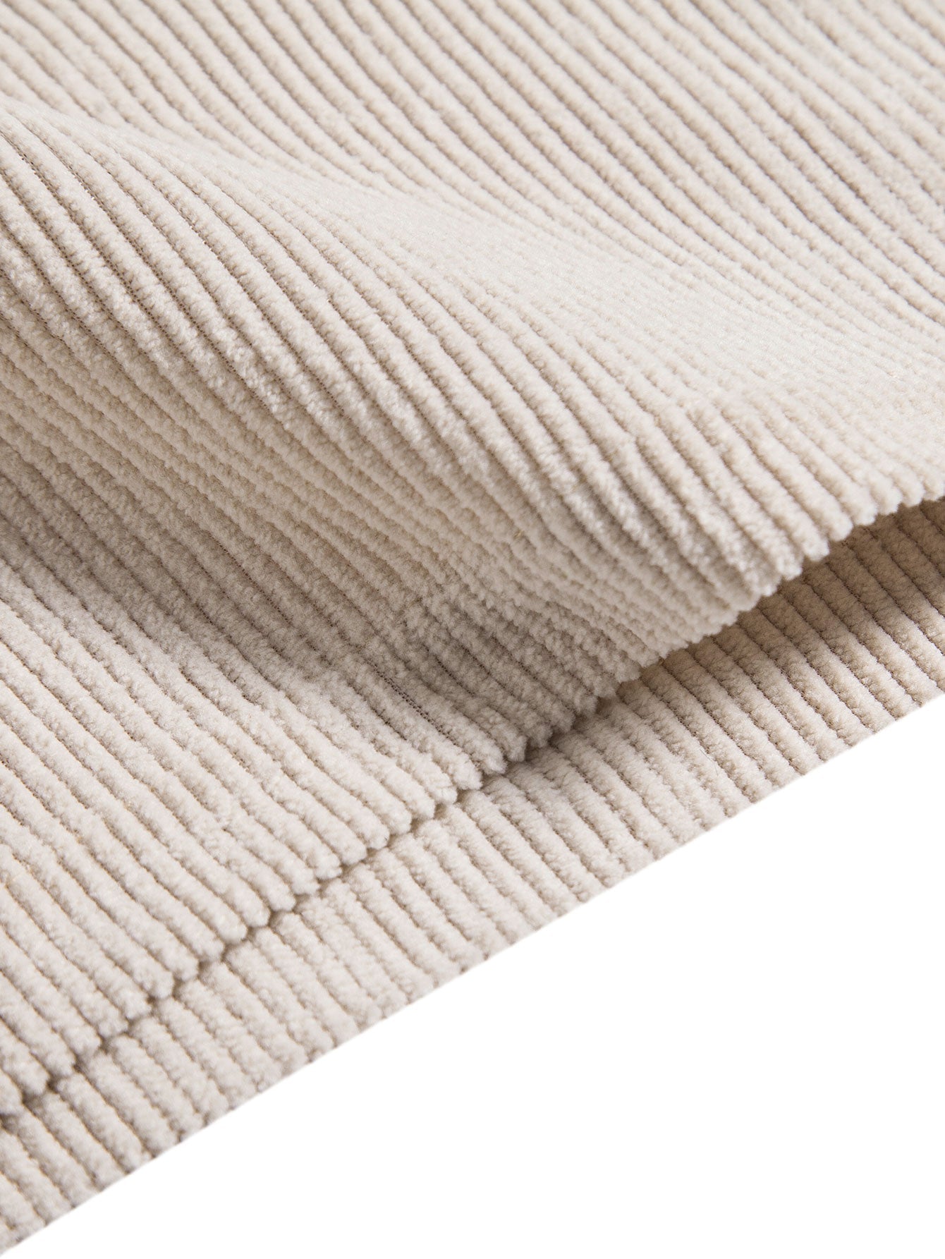 Close-up of beige corduroy fabric with a white background
