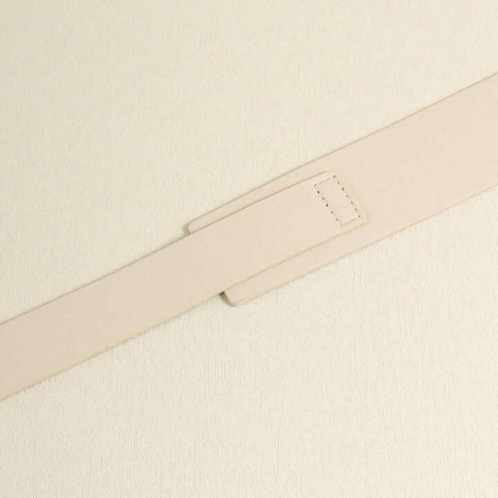 Close-up of a beige belt on a matching fabric background