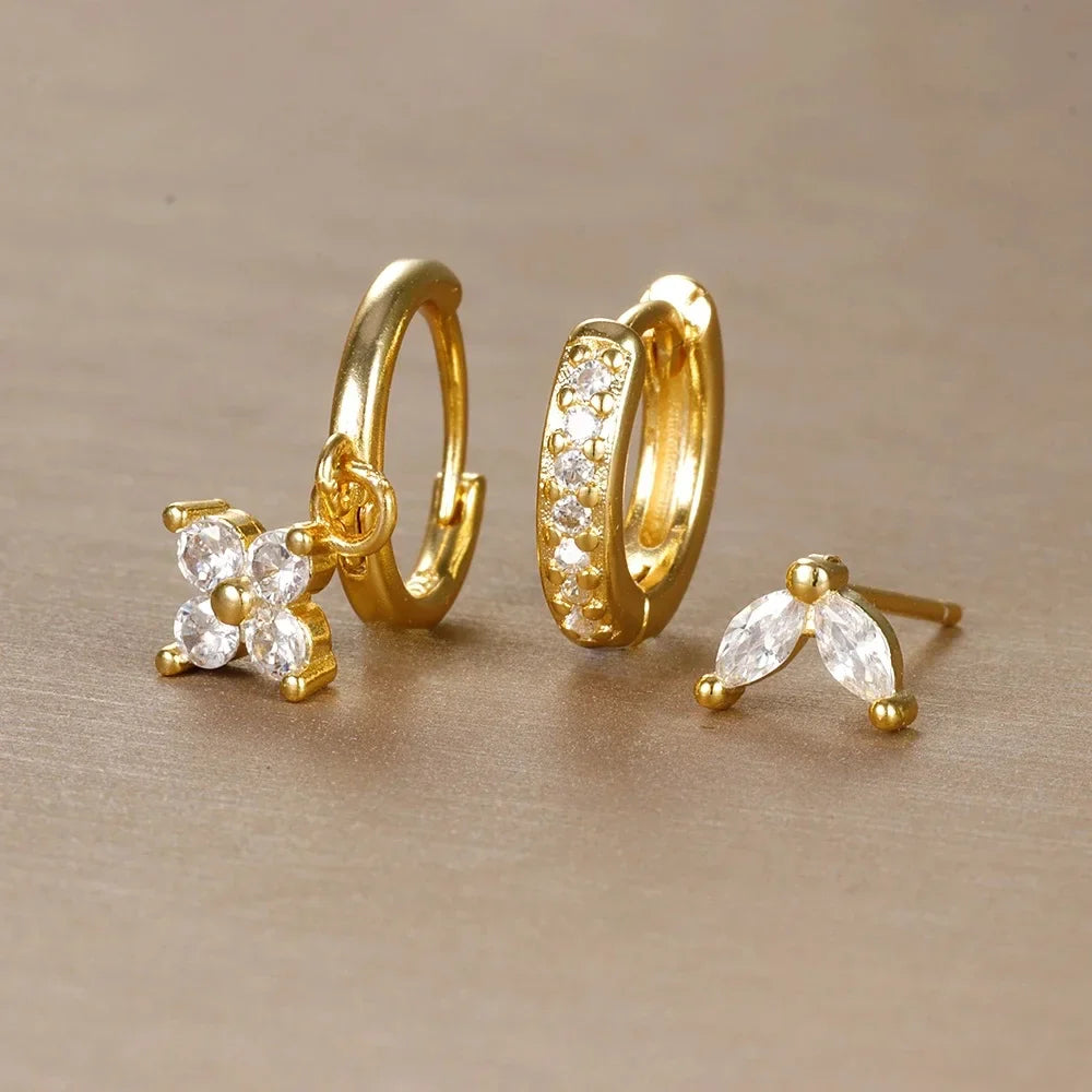 Set of gold earrings on a beige background