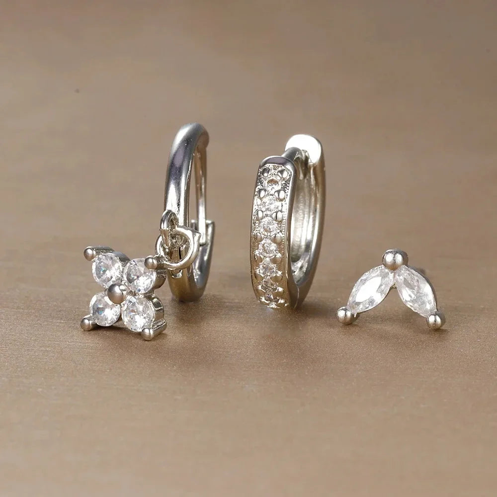 Set of silver earrings on a beige background
