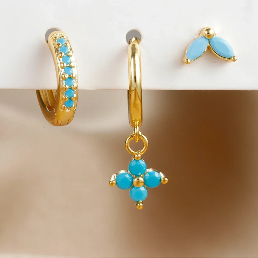 Set of gold and turquoise earrings on a beige surface with '3pcs' text.