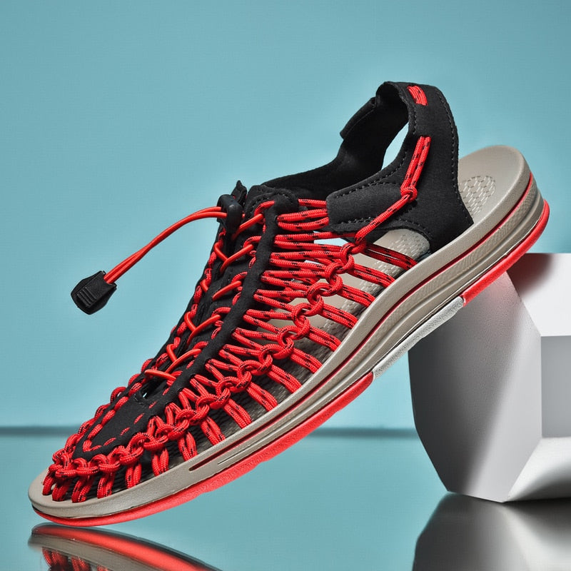 Black and red sandal on a reflective surface with a blue background