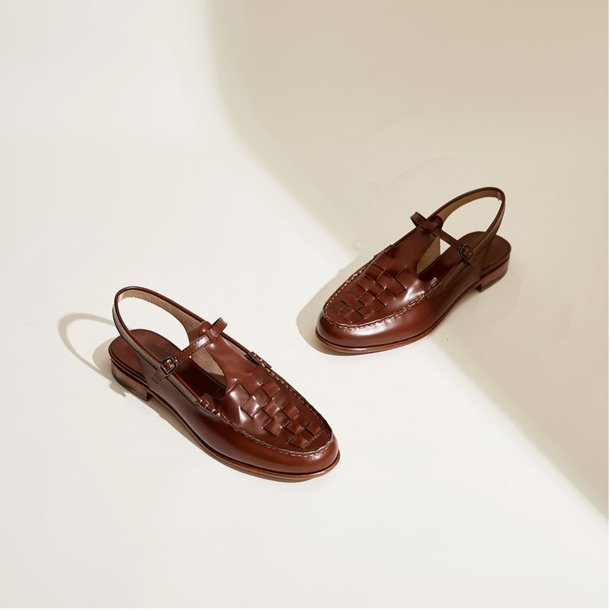 Pair of brown sandals on a light beige background