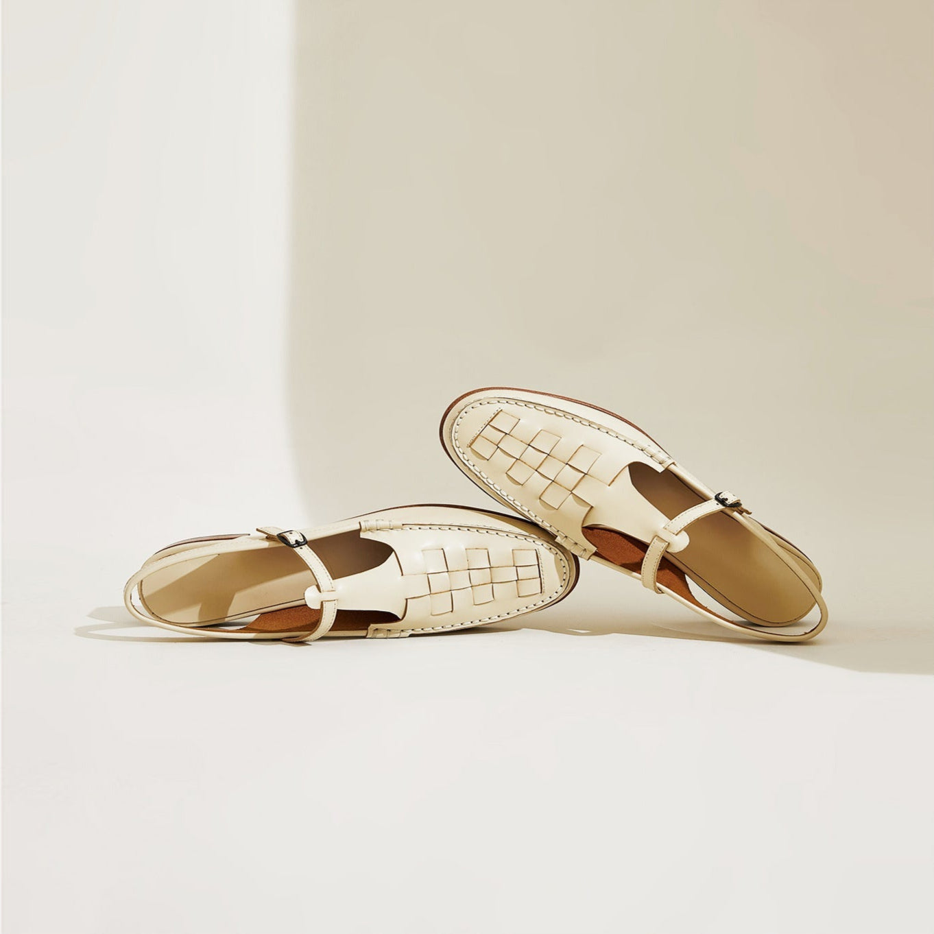 Pair of gold loafers on a light beige background