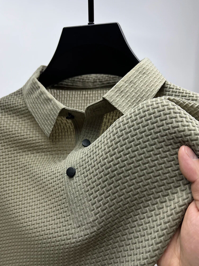 Green textured shirt on a hanger with a hand holding it