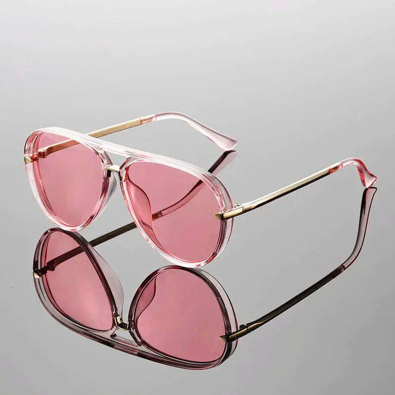 Pink sunglasses with gold frames on a gray background