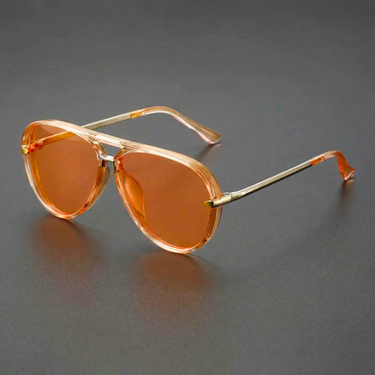 Orange sunglasses with gold frames on a gray background
