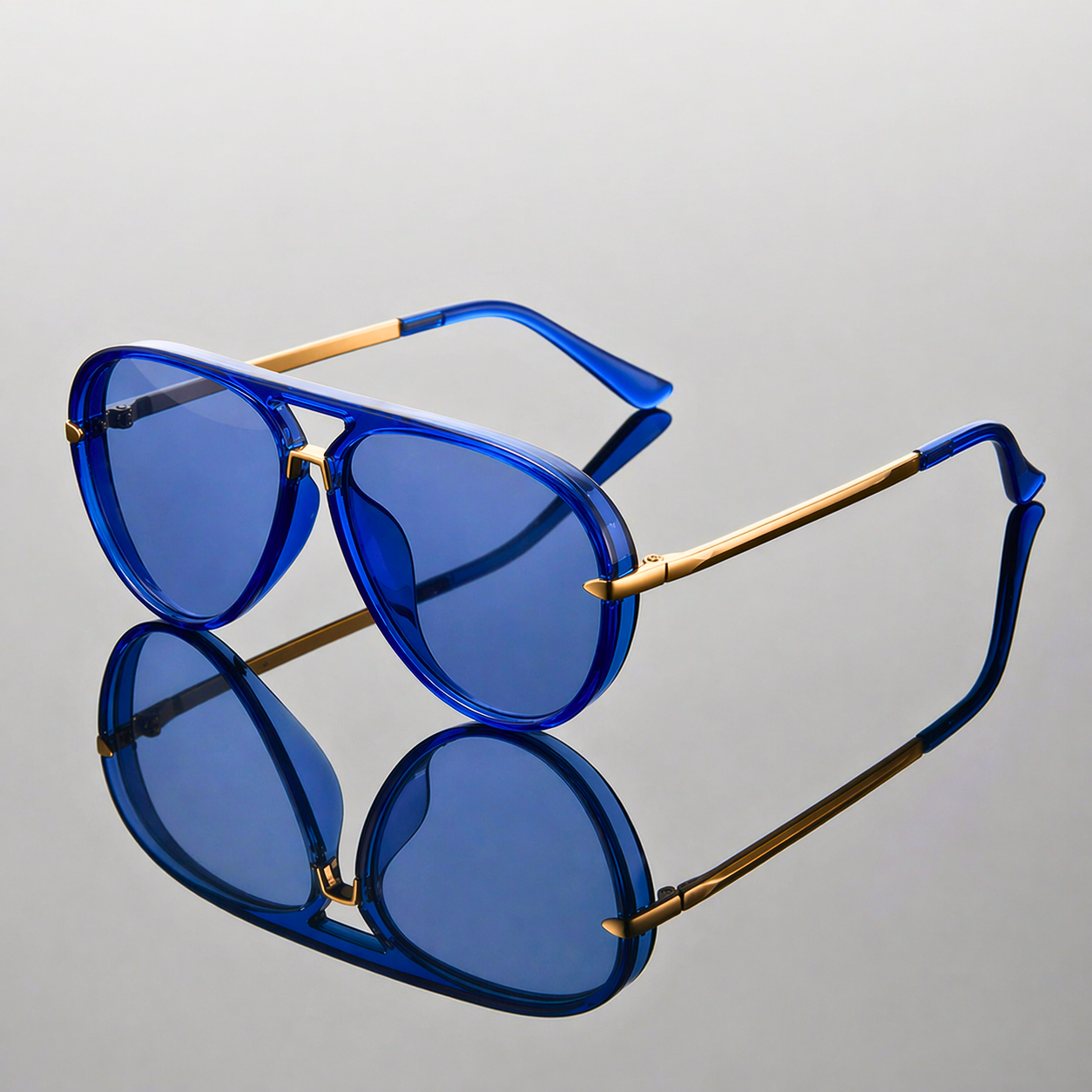 Blue sunglasses with gold accents on a gray background