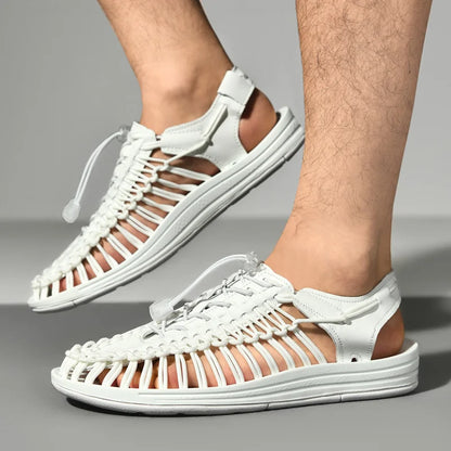 White woven sandals worn by a person on a gray background