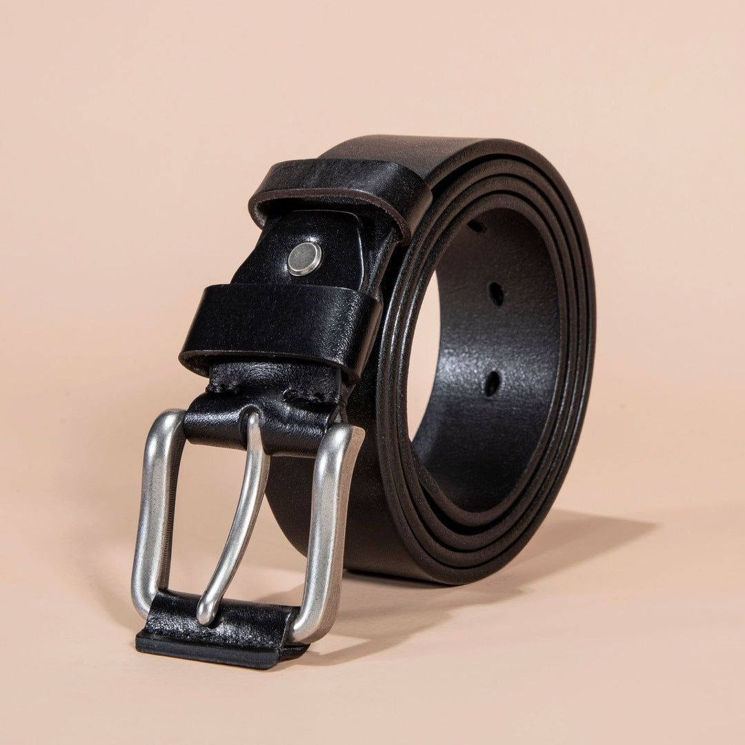 Black leather belt with silver buckle on a beige background