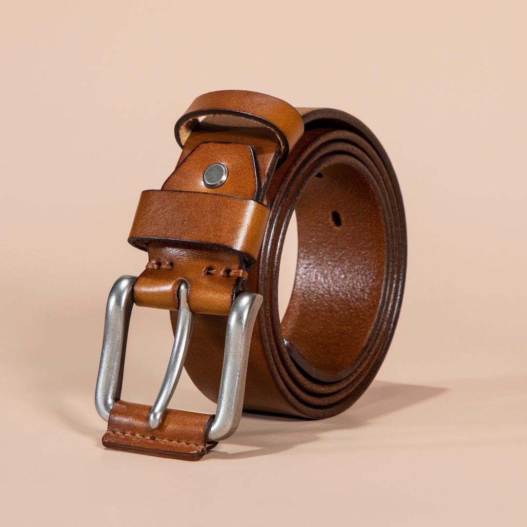 Brown leather belt with silver buckle on a beige background