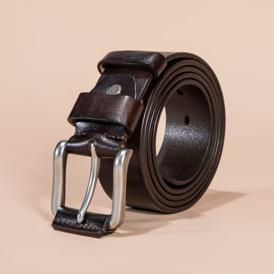 Brown leather belt with silver buckle on a beige background