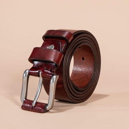 Brown leather belt with silver buckle on a beige background