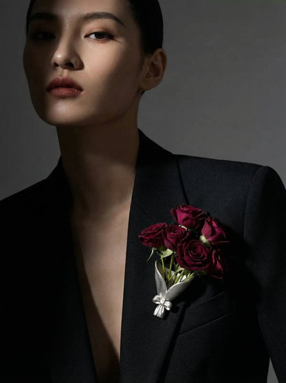 Person wearing a black suit with red roses on a dark background