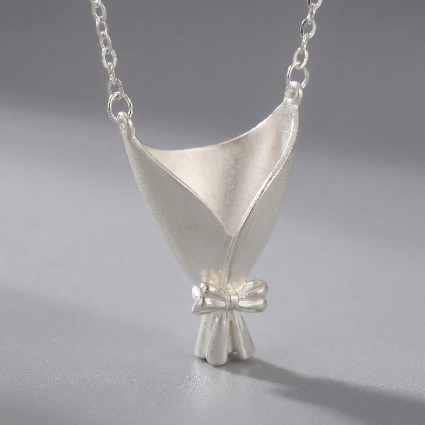 Silver pendant necklace on a gray background
