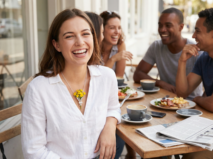 Woman smiling at a table with friends in a cafe