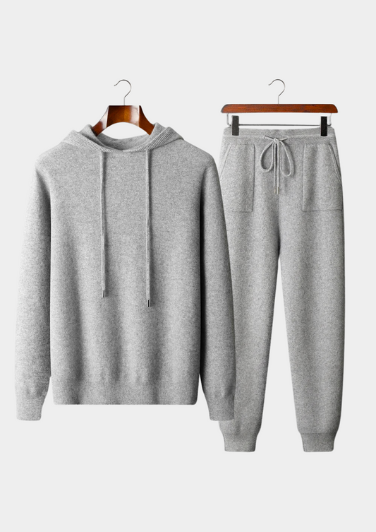 Gray hoodie and jogger pants set on hangers against a white background