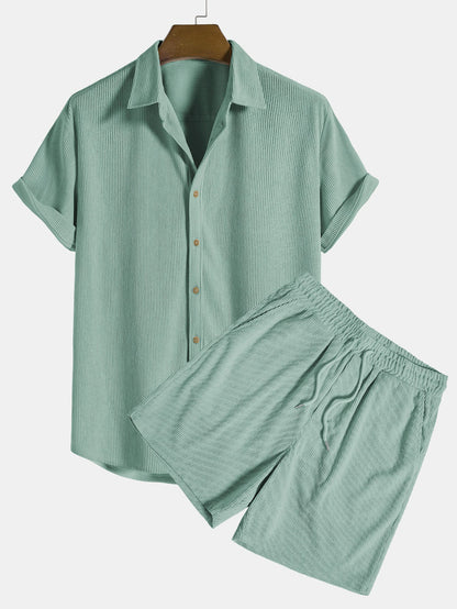 Green checkered shirt and shorts set on a hanger against a white background