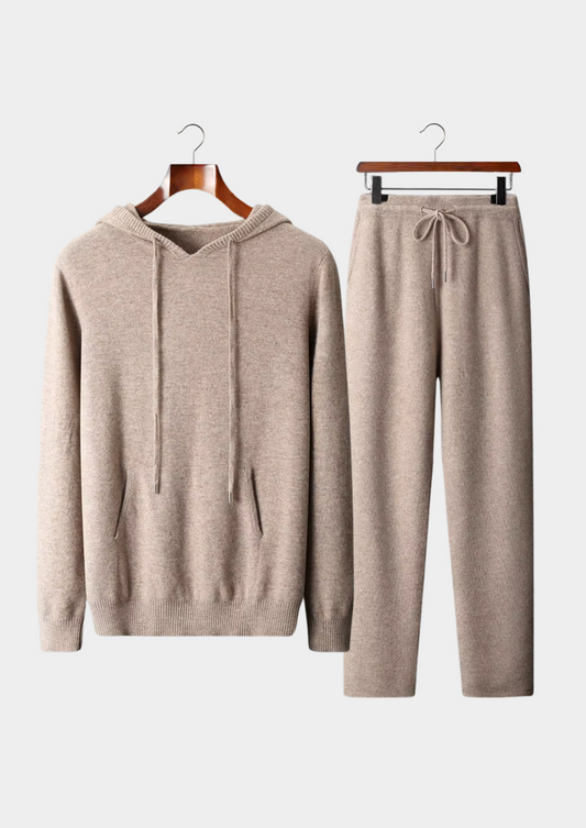 Beige hoodie and pants set on hangers against a white background