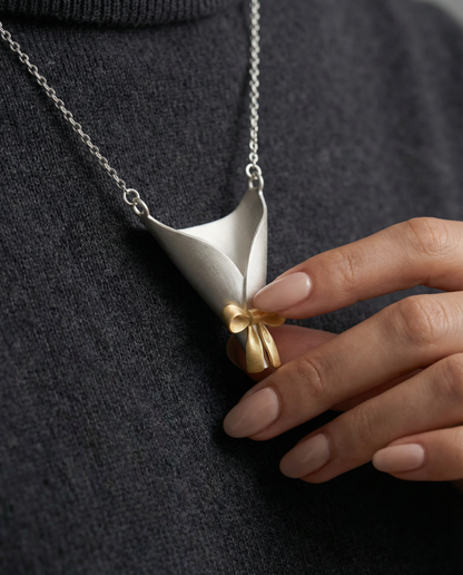 Necklace with a unique pendant held by a hand against a dark background
