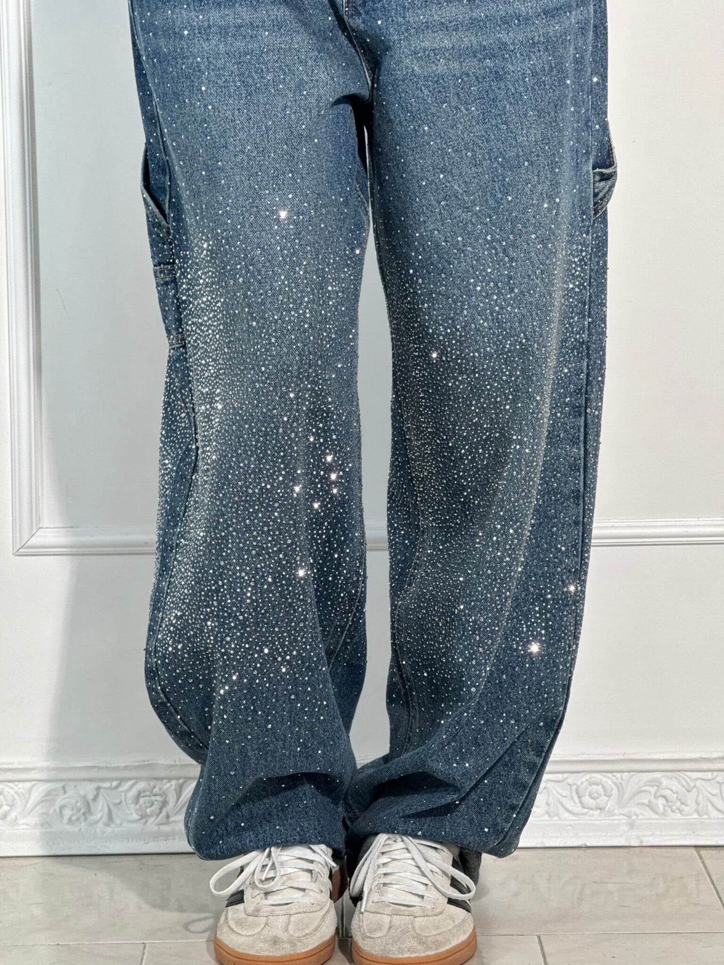 Blue sparkly pants worn by a person on a white background