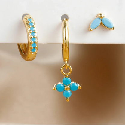 Set of gold and turquoise earrings on a beige surface with '3pcs' text.