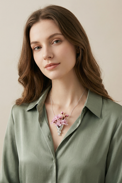 Woman wearing a green shirt with a floral necklace against a beige background