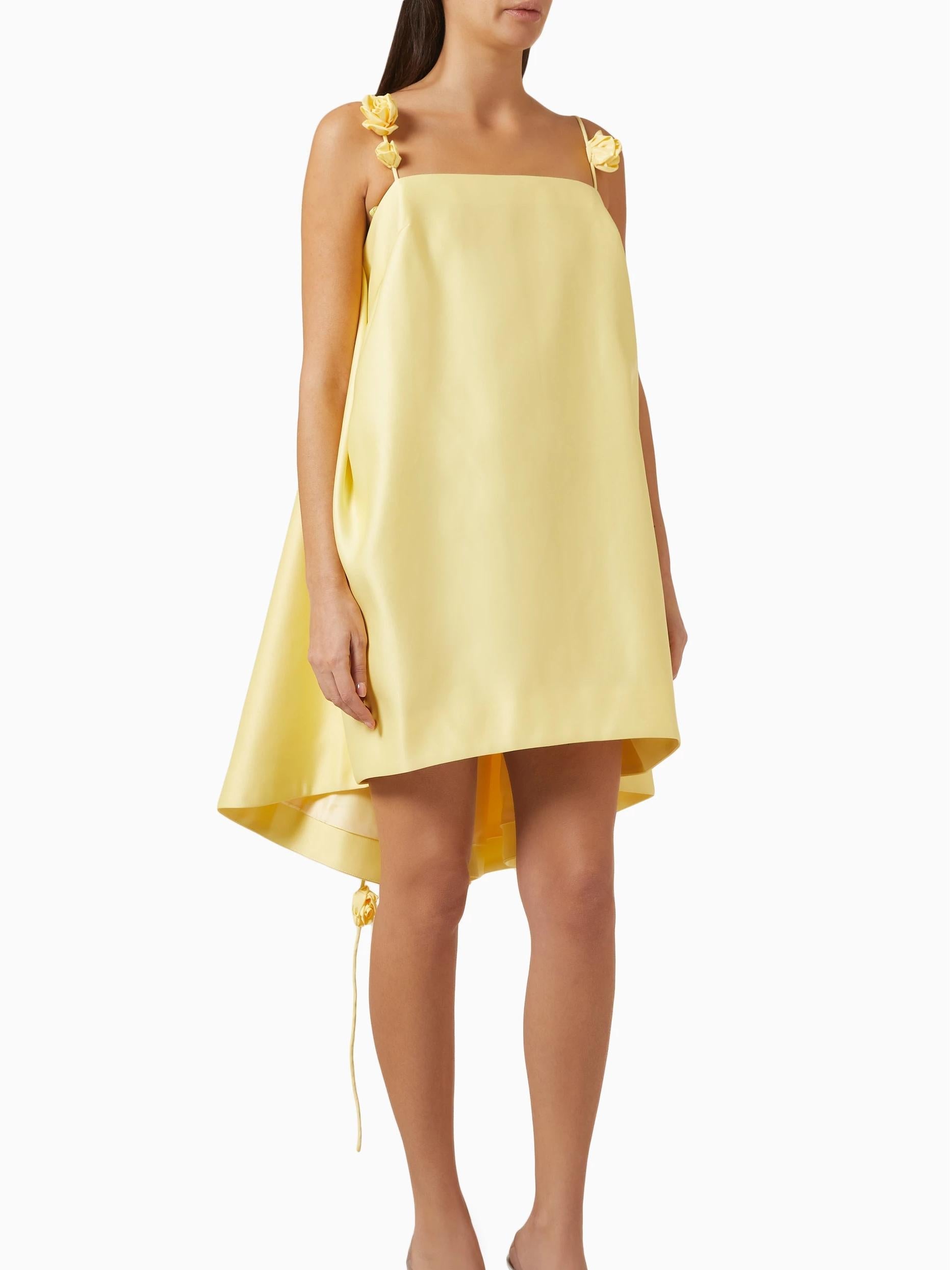 Yellow dress with floral straps worn by a model on a white background
