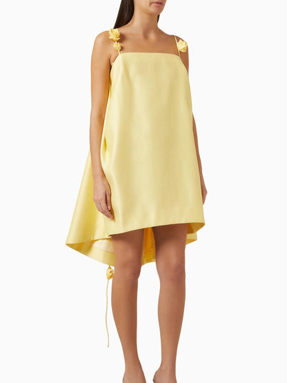 Yellow dress with floral straps worn by a model on a white background