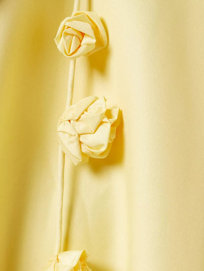 Three cream-colored roses on a yellow background