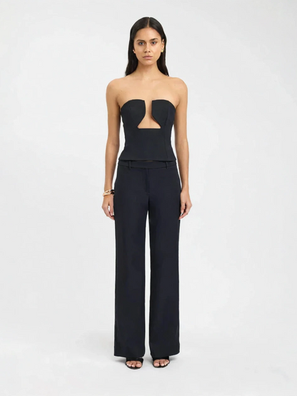 Woman wearing a black strapless jumpsuit on a white background