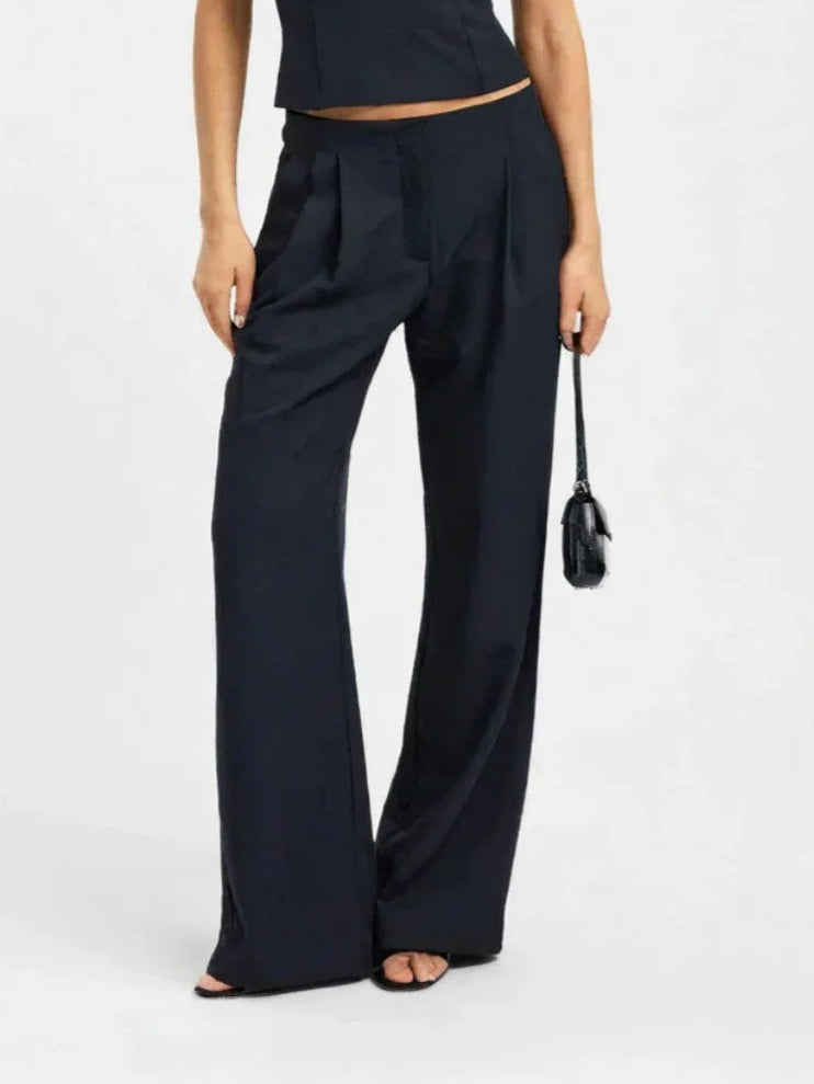 Person wearing navy wide-leg pants on a white background