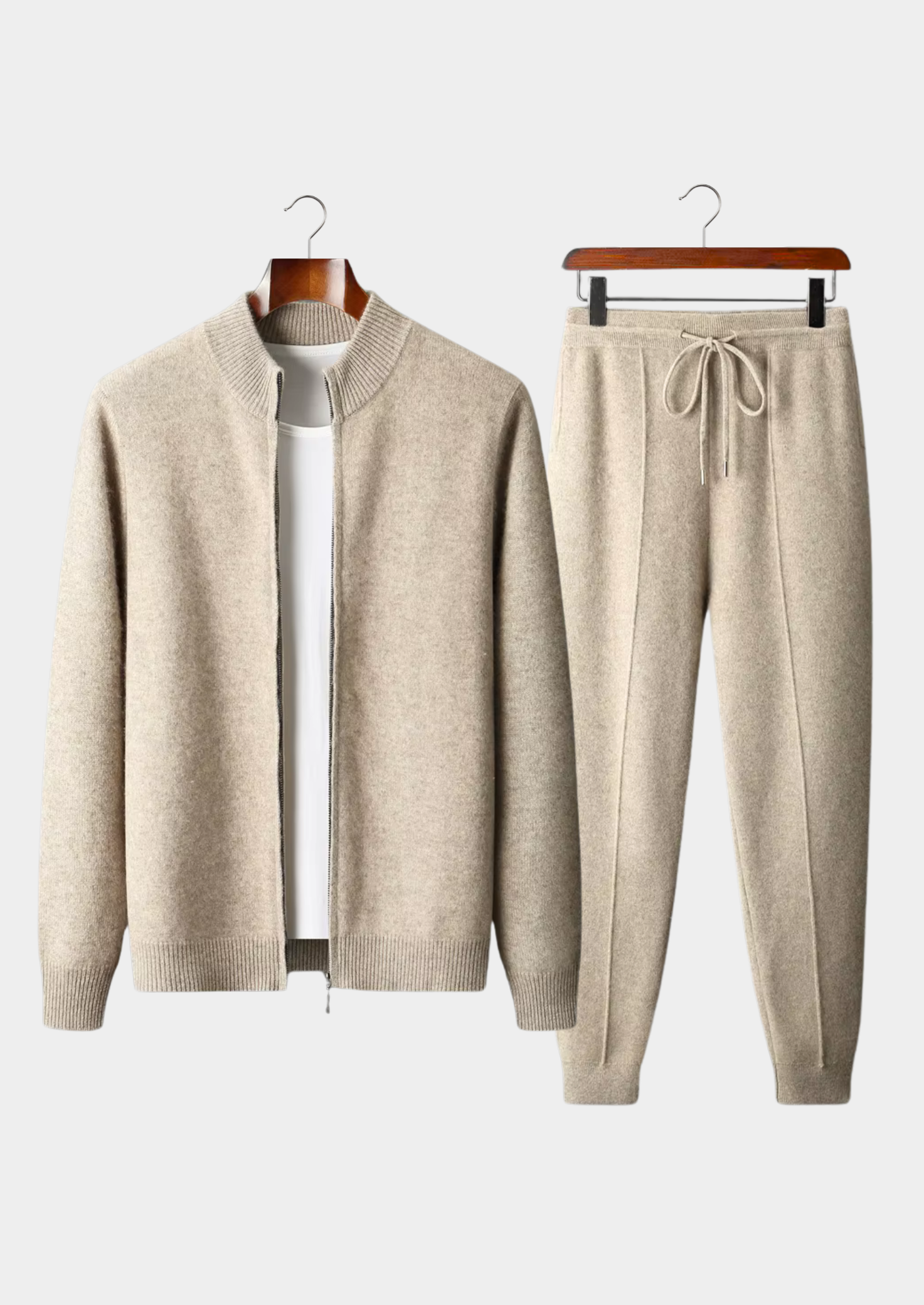 Beige cardigan and jogger pants set on hangers against a white background