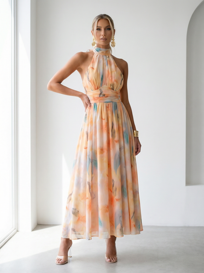Woman wearing a colorful halter neck dress in a bright room.