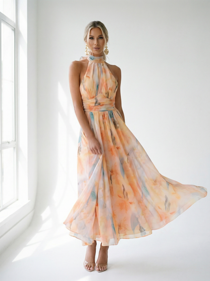 Woman wearing a long, flowing dress with a colorful pattern in a bright room.