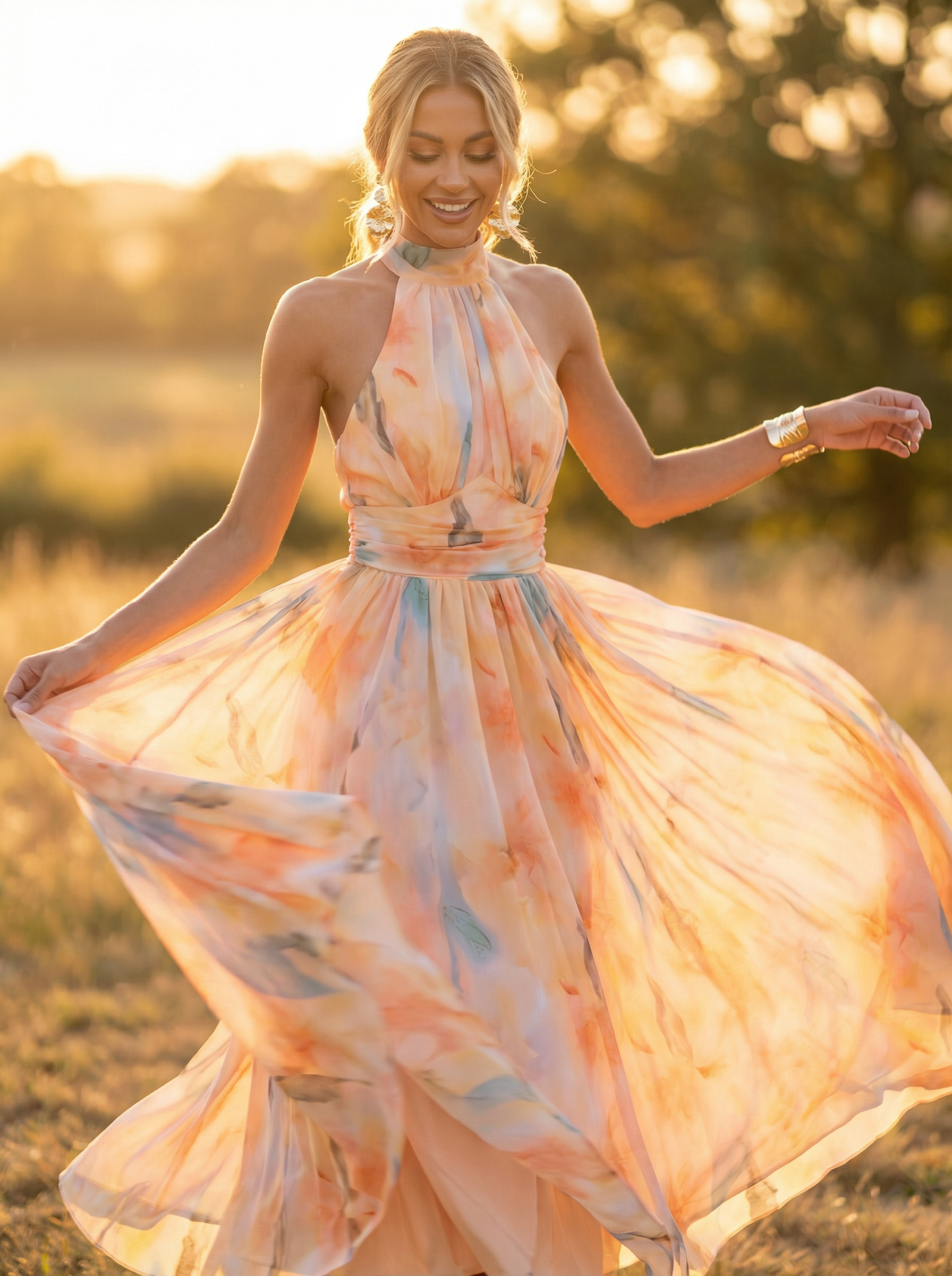 Woman in a flowing dress standing in a field with a warm, blurred background