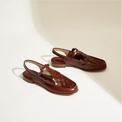 Pair of brown leather sandals on a light beige background