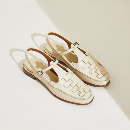 Pair of cream-colored loafers with woven design on a light background