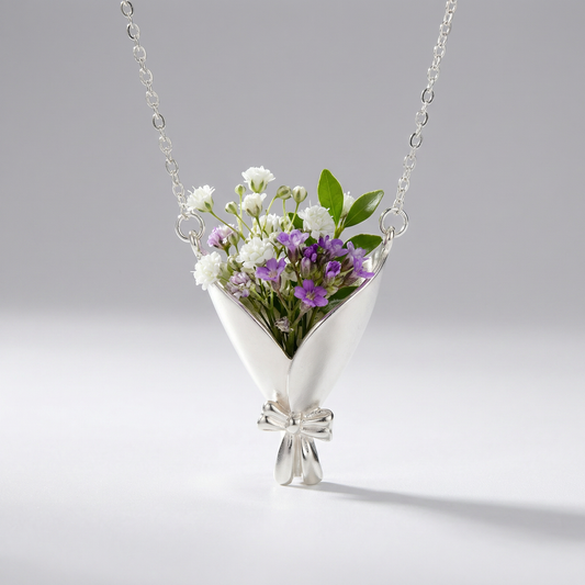 Silver necklace with a floral pendant on a gray background