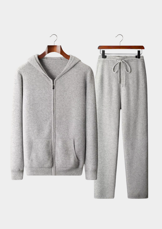 Gray tracksuit with a hoodie and pants on hangers against a white background