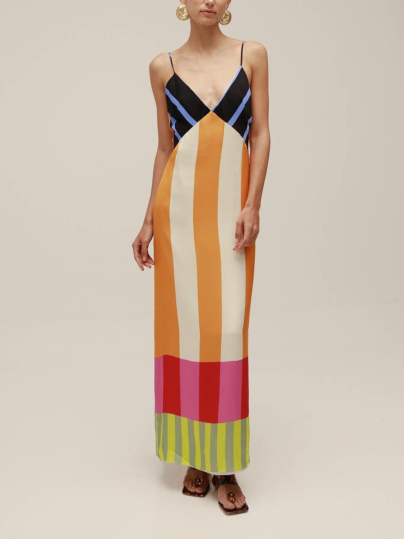Woman wearing a colorful striped dress on a beige background