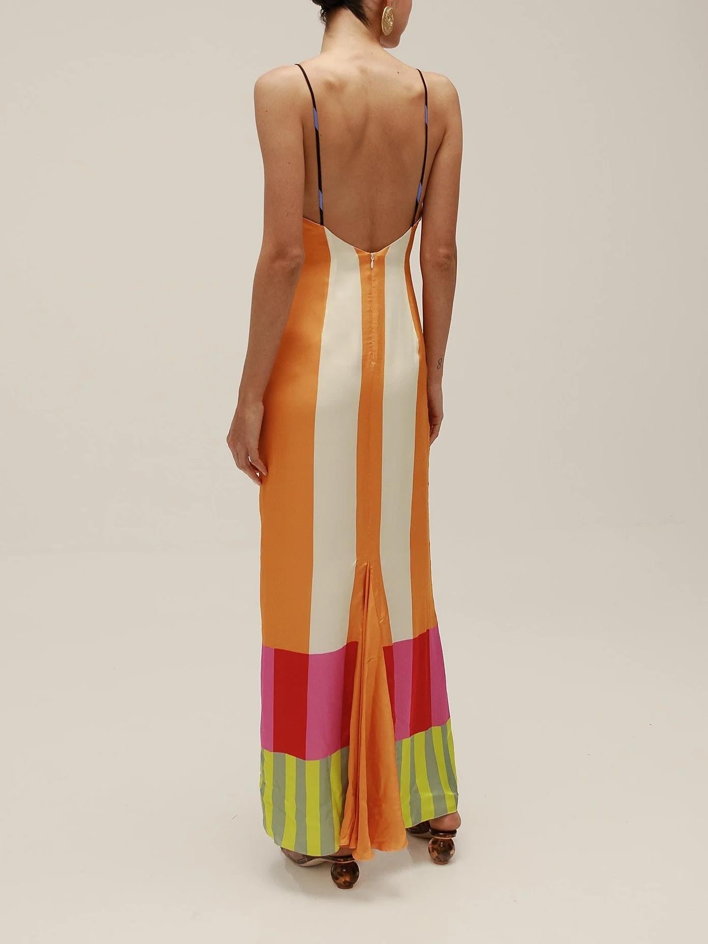 Woman wearing a colorful striped dress with a plain background