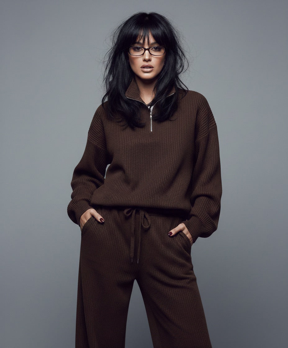 Person wearing a brown outfit against a gray background
