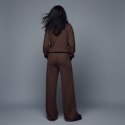 Person wearing a brown outfit against a gray background