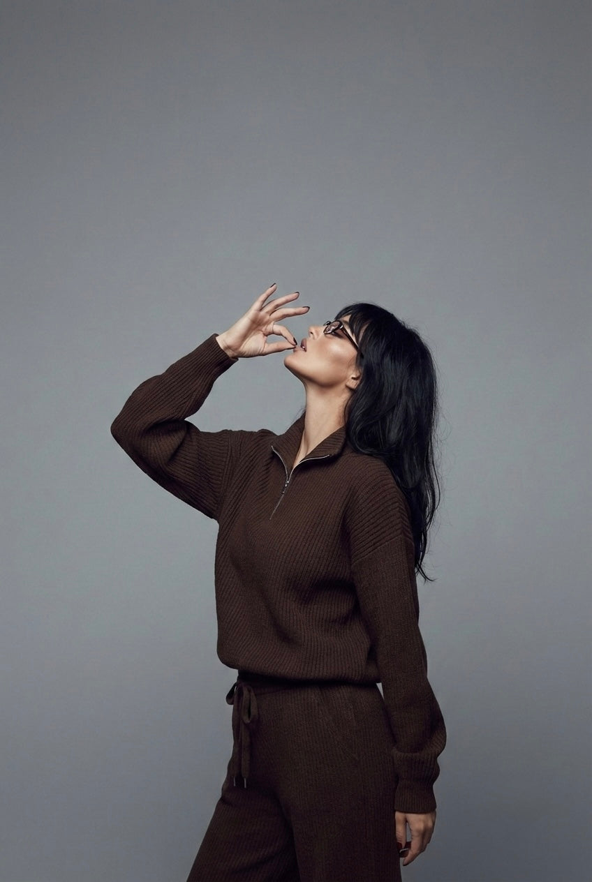 Woman in a brown outfit posing against a gray background